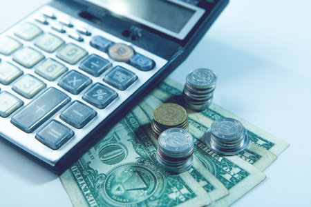 Calculator and money on white background, business and finance concept