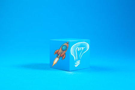 Start up concept with rocket and lightbulb on blue background.