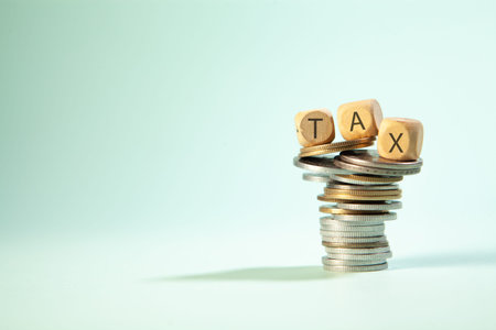 Coins stacked on each other and the word TAX. Business conceptの写真素材