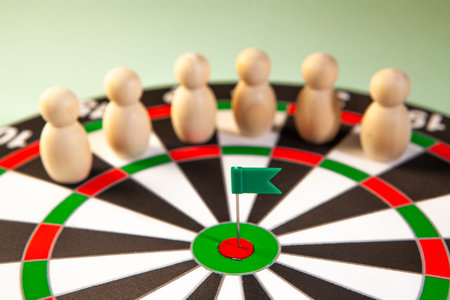 Dartboard with green flag and wooden figures of people on it