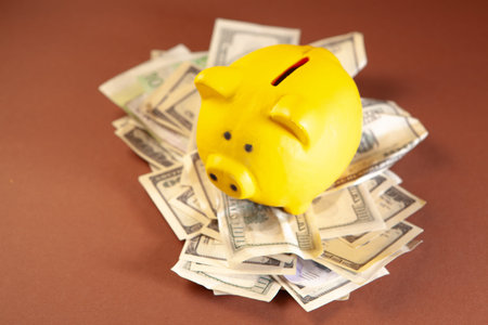 Piggy bank with money on brown background. Save money conceptの写真素材