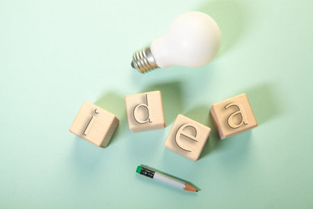 Idea word made of wooden cubes with lightbulb and pencil