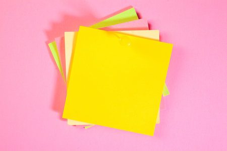 Colorful sticky notes on a pink background with space for text.