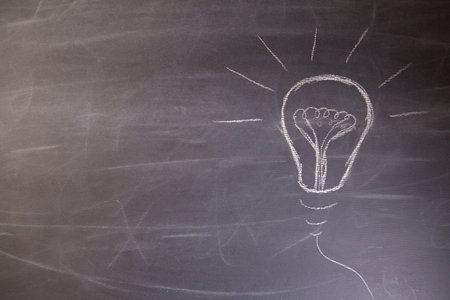 Light bulb drawn with chalk on a blackboard. Business idea concept.