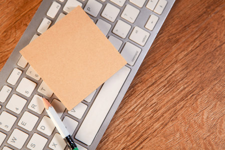laptop with blank note on wooden desk. business concept.