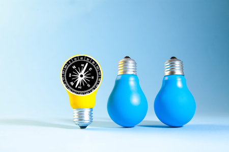 Energy saving light bulb and compass on blue background. Energy saving concept.