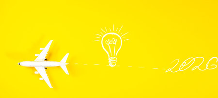 Light bulb and airplane on yellow background. Concept of idea and innovationの写真素材