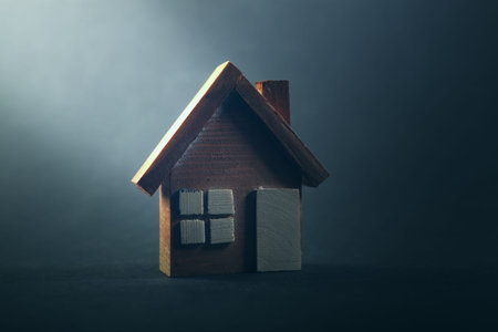 Wooden toy house on a dark background. The concept of buying or selling real estate.
