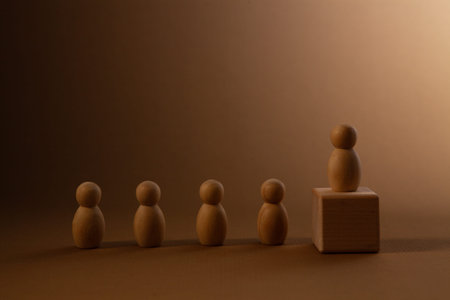 Wooden figures of people stand on a wooden cube. The concept of leadership and teamwork.