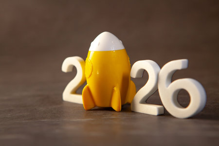 Happy new year 2026 with toy rocket on wooden background, new year concept