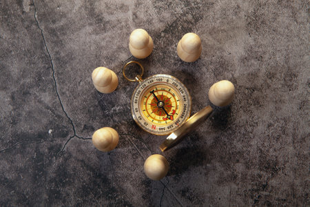 Compass and wooden spheres on grey background. Top view with copy space