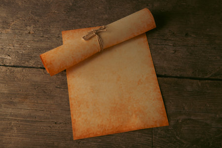 Old paper scroll on wooden background. Vintage style toned picture.