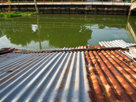 Cavities Old tin roof of the boathouse beside drainage canalsの写真素材
