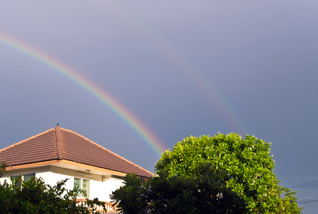 Big rainbow over the roofの写真素材
