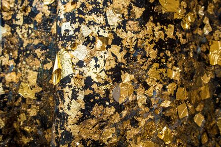 Golden leaf taped on the Buddha statueの写真素材