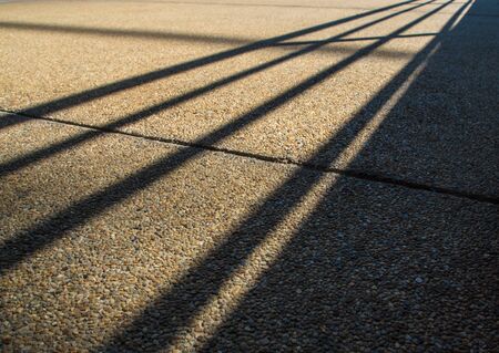 Shadow of steel fence grafted onto rough anti-slip concrete floorの写真素材