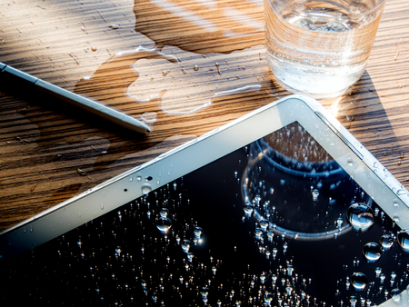 Water spilled onto the tablet, Drops of water on tablet screenの写真素材