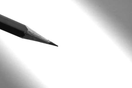 The pencil holding to write on the paper in shadowの写真素材