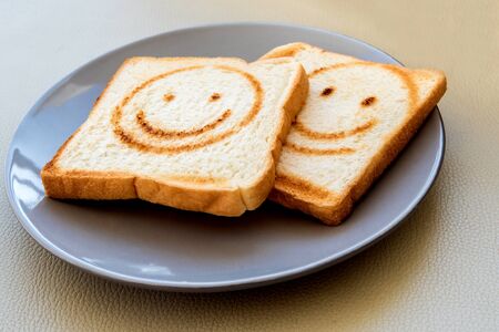 Burning line as happy face on the bread sheetの写真素材