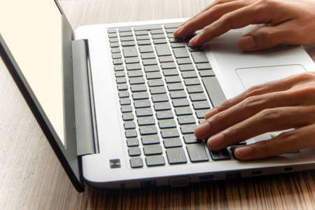 A man working with laptop on wooden table