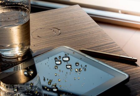 Water spilled onto the tablet, Drops of water on tablet screenの写真素材