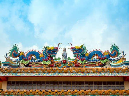 Colorful twin chinese dragon statues adorned the rooftops of pavilions in Chinese religious venuesの写真素材