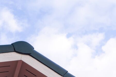 Gabled roof under a clouds and blue sky