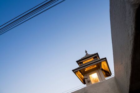 Warm tone lighting from the decorated lamps on the fence postの写真素材