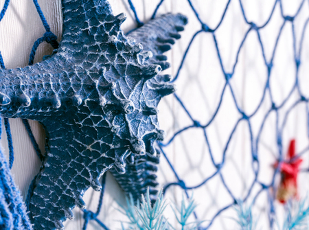 Blue net and artificial starfish made of plastic decorate in the beach and sea theme on wallの写真素材