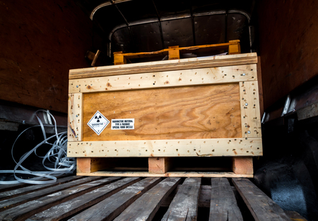 Radiation warning sign on the Hazardous materials transport label Class 7 at the wooden box package in the container of transport truckの写真素材