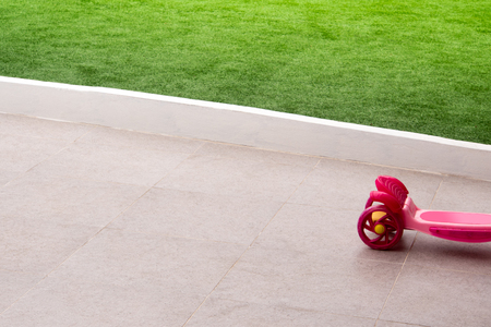 The part of plastic toy, scooter for kids at the home gardenの写真素材