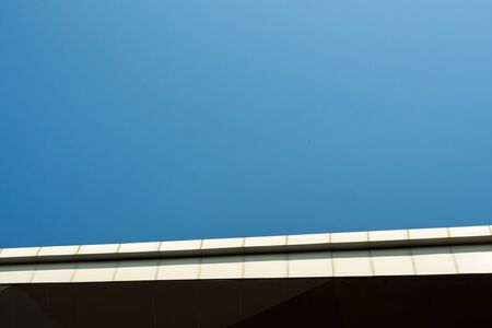 The edge of building roof and the copy space on clear blue sky