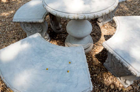 Stucco outdoor table set on the gravel floor in the gardenの写真素材