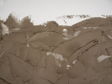 Plastering cement on a reinforcing plastic grid on a foam boardの写真素材