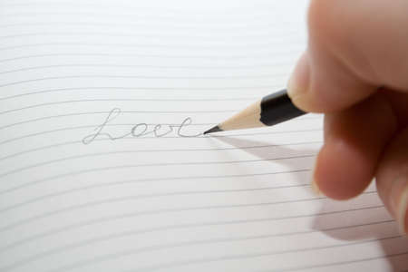 pencil in hand writing love over blank notes