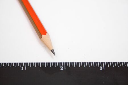 pencil and black ruller on the white isolated background