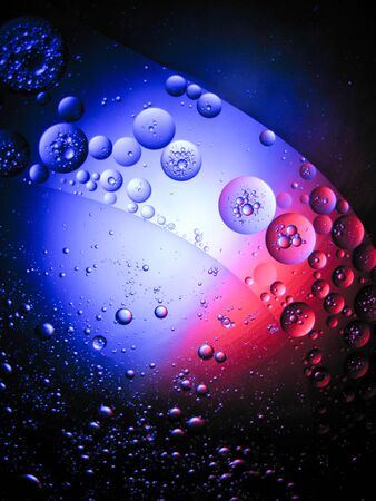 floating drop oil on the water with difference colour light, moving around look like a plant in spaceの写真素材