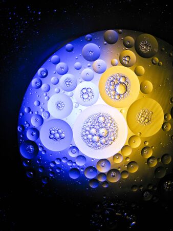 floating drop oil on the water with difference colour light, moving around look like a plant in spaceの写真素材