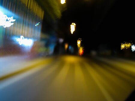 Blurred motion of defocused road on the dark night - very shaky long exposure picture of road on the...