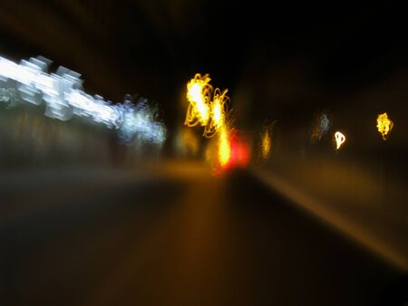 Blurred motion of defocused road on the dark night - very shaky long exposure picture of road on the dark night - abstract long exposure night roadの写真素材