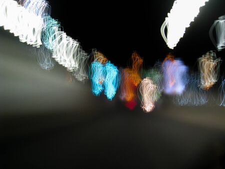 Blurred motion of defocused road on the dark night - very shaky long exposure picture of road on the dark night - abstract long exposure night roadの写真素材