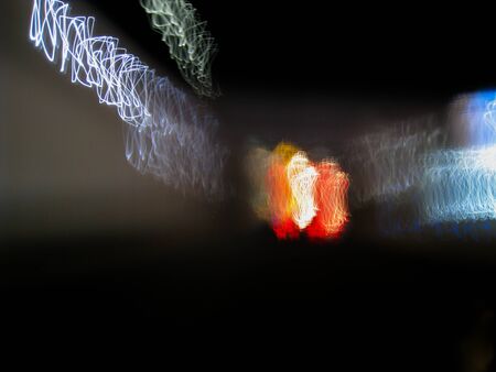 Blurred motion of defocused road on the dark night - very shaky long exposure picture of road on the...