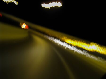 Blurred motion of defocused road on the dark night - very shaky long exposure picture of road on the dark night - abstract long exposure night roadの写真素材