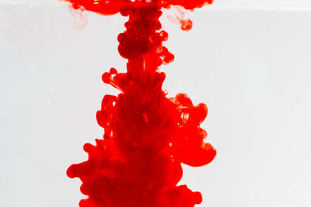 out of focus red ink drop in crystal clear water, soft focus of red ink in clear water,