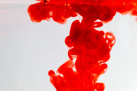 out of focus red ink drop in crystal clear water, soft focus of red ink in clear water,の写真素材