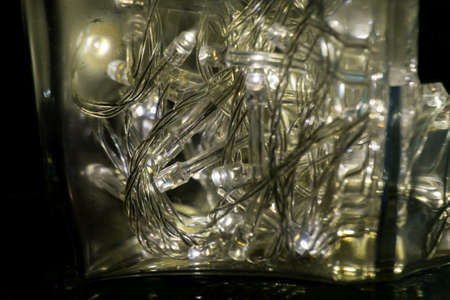 many LED bulb with electric wire in the clear glass bottle, power of light make water drop from moisture in the bottleの写真素材