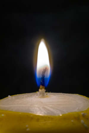 small fire on top of candle in dark backgroundの写真素材