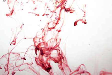 selective soft focus red liquid like blood drop in to clear waterの写真素材
