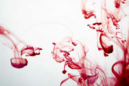 selective soft focus red liquid like blood drop in to clear waterの写真素材