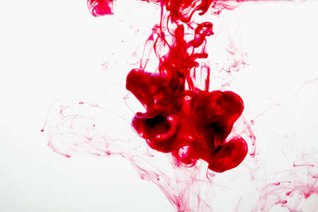selective soft focus red liquid like blood drop in to clear waterの写真素材